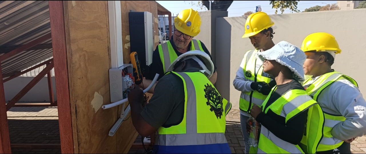 Assessor observing a candidate wiring an inverter distribution board